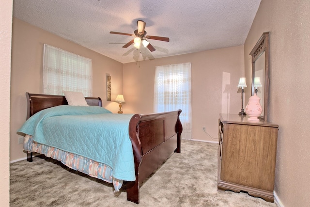 bedroom with a textured ceiling, light colored carpet, and ceiling fan