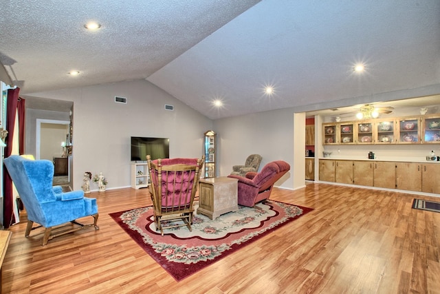 living room featuring vaulted ceiling and light hardwood / wood-style flooring