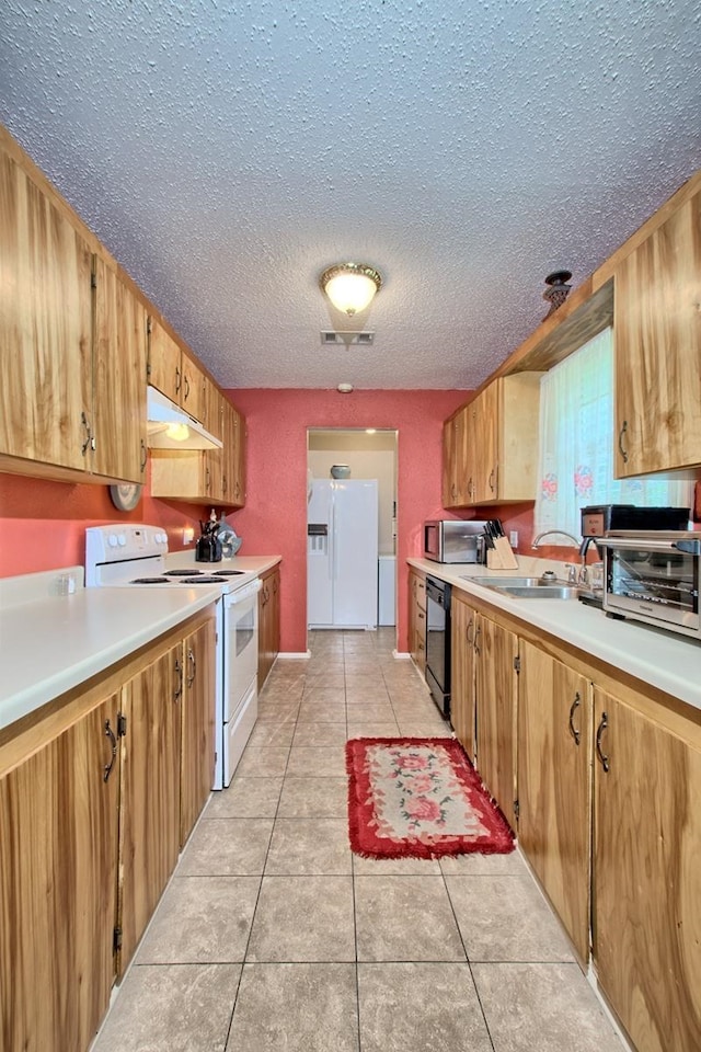 kitchen featuring a textured ceiling, white appliances, sink, and light tile patterned floors