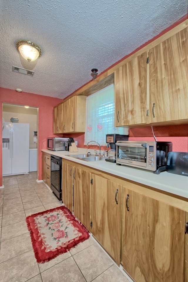 kitchen featuring a textured ceiling, sink, light tile patterned floors, dishwasher, and white fridge with ice dispenser