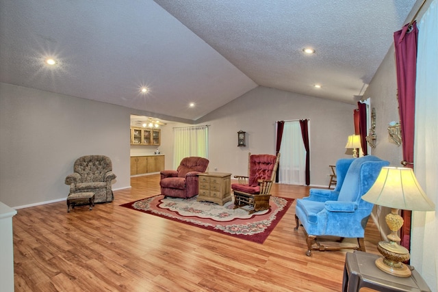 living area featuring hardwood / wood-style flooring and vaulted ceiling