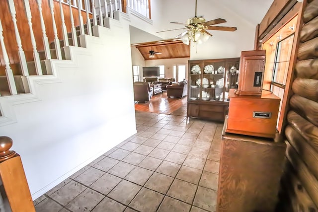 entryway with tile patterned flooring, stairway, high vaulted ceiling, and a ceiling fan