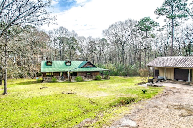 view of yard with covered porch and dirt driveway