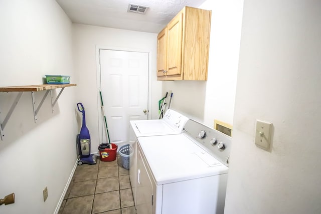 washroom with visible vents, washer and clothes dryer, cabinet space, light tile patterned flooring, and baseboards