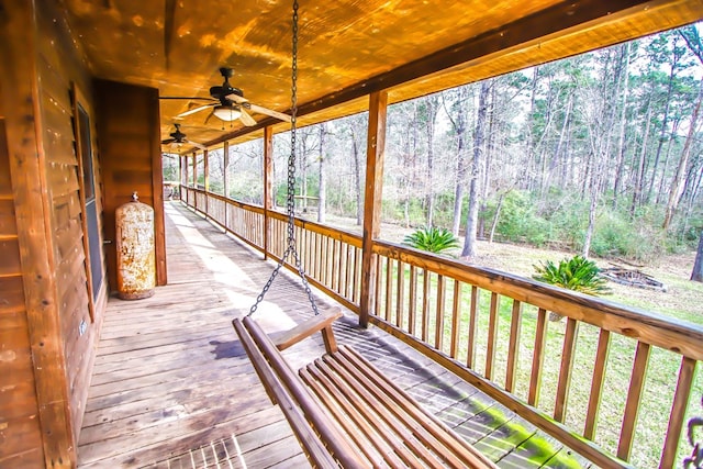 deck featuring ceiling fan and a wooded view