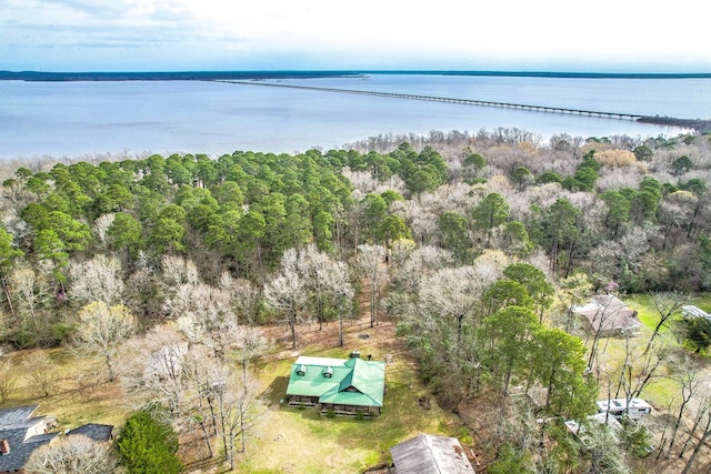 drone / aerial view featuring a wooded view and a water view