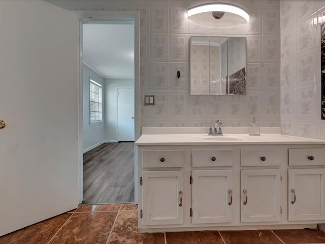 bathroom with baseboards, vanity, and crown molding