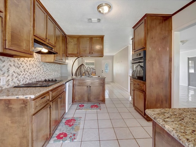 kitchen featuring light tile patterned flooring, under cabinet range hood, a peninsula, a sink, and black appliances