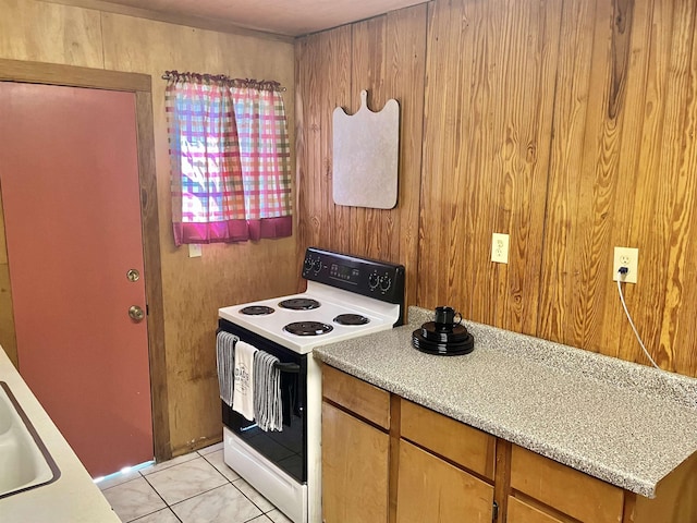 kitchen with wood walls, sink, light tile patterned floors, and white electric range