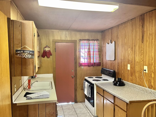 kitchen with wood walls, light tile patterned flooring, white electric range, and sink