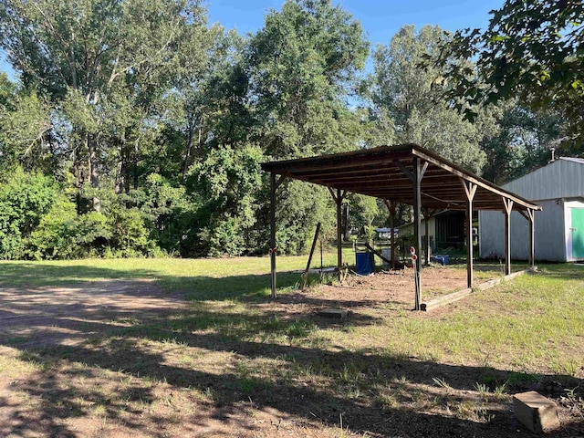 view of yard featuring a carport and an outbuilding