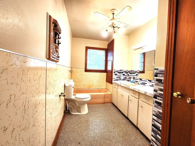 carpeted spare room with ceiling fan, plenty of natural light, and a textured ceiling