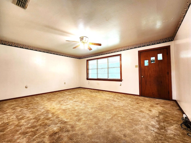 carpeted foyer entrance featuring ceiling fan, crown molding, and a textured ceiling