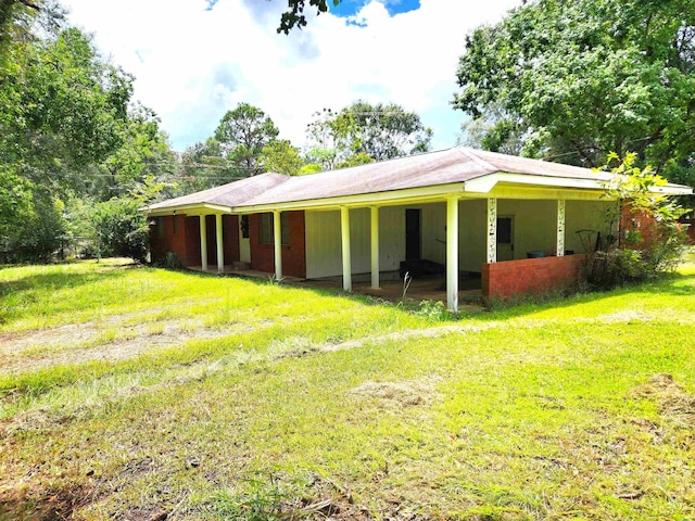 exterior space with an attached carport and a lawn
