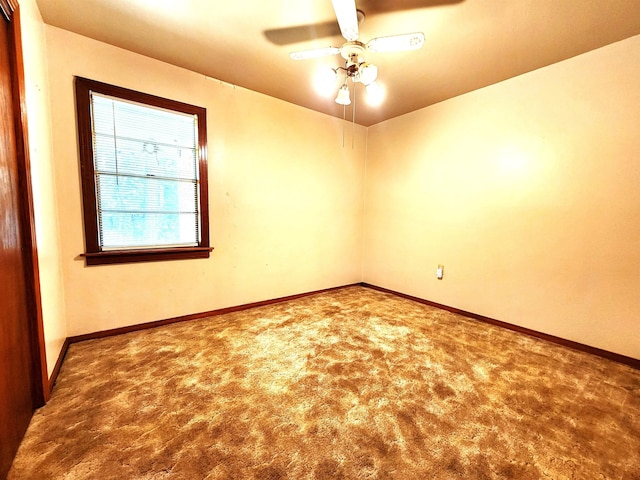 spare room with baseboards, carpet floors, and ceiling fan