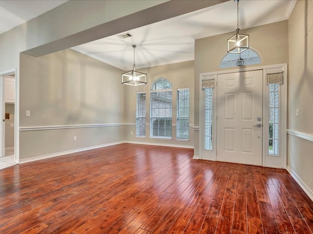 entryway featuring ornamental molding, wood finished floors, visible vents, and baseboards