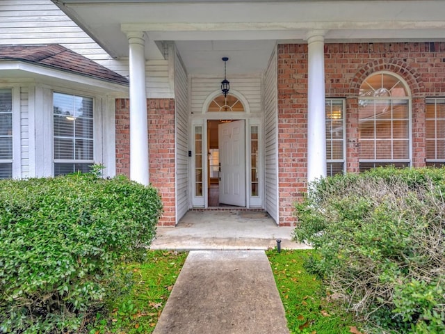 doorway to property featuring brick siding