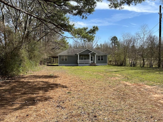 view of front of home with a front lawn and dirt driveway