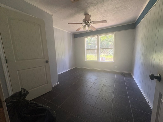 1169 County Road 619, Kirbyville, TX 75956 - empty room with crown molding, ceiling fan, a textured ceiling, wooden walls, and baseboards