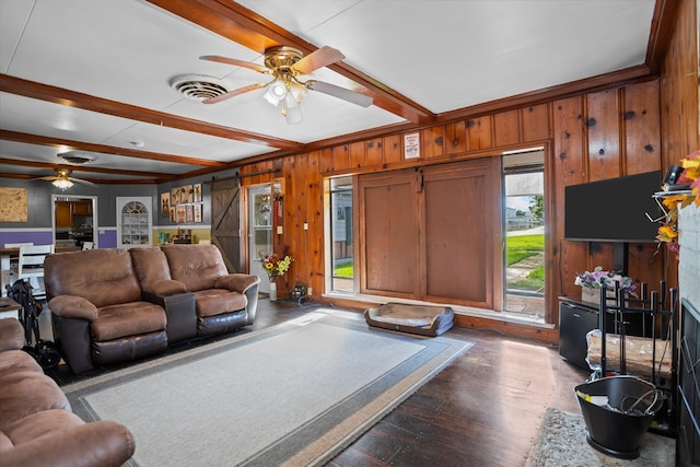 505 S Home St, Corrigan, TX 75939 - living area with a ceiling fan, beamed ceiling, wooden walls, and dark wood-type flooring