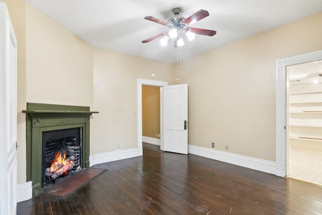 250 Main St, Jasper, TX 75951 - unfurnished living room featuring a lit fireplace, hardwood / wood-style floors, a ceiling fan, and baseboards