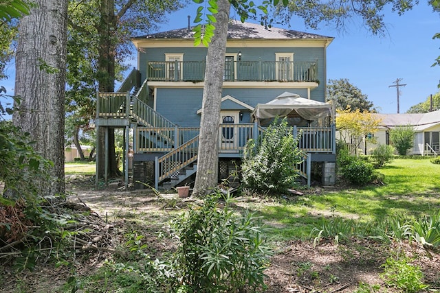 250 Main St, Jasper, TX 75951 - rear view of property featuring stairway, a balcony, and a deck