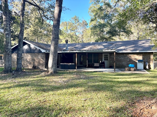 rear view of property featuring a patio area and a yard