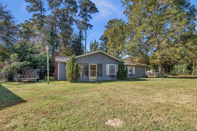 back of property featuring a lawn and a trampoline