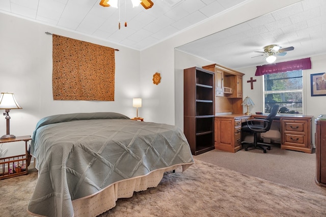 carpeted bedroom with ceiling fan and ornamental molding