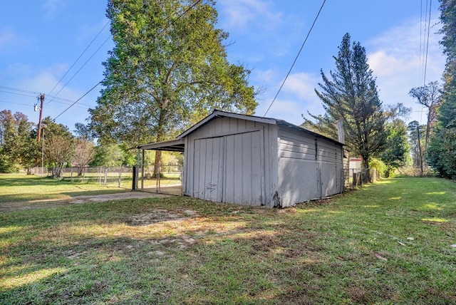 view of outbuilding featuring a carport and a lawn