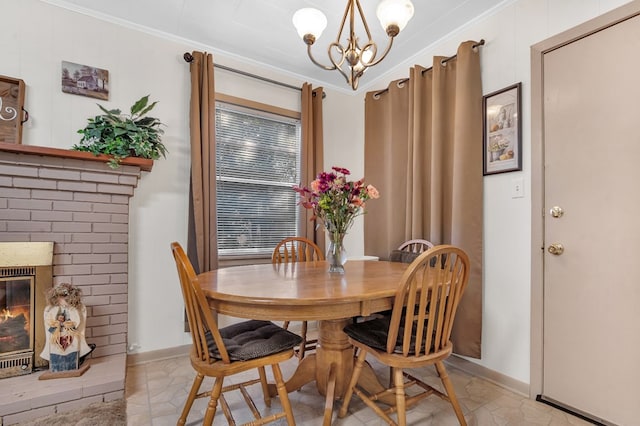 dining room featuring a brick fireplace, ornamental molding, and a notable chandelier