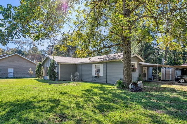 rear view of house featuring a lawn, cooling unit, and a carport