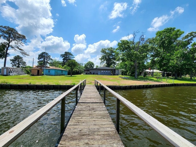 dock area with a yard and a water view