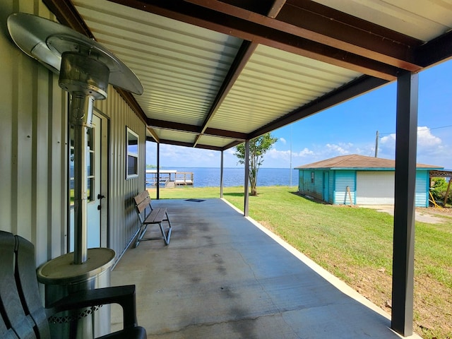 view of patio / terrace with a detached garage and a water view