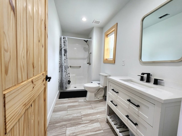 full bathroom featuring a shower stall, vanity, toilet, visible vents, and baseboards