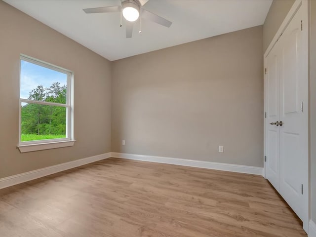 unfurnished bedroom with baseboards, multiple windows, and light wood-type flooring