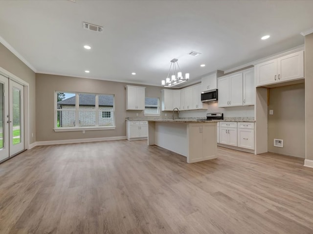 kitchen with a sink, stainless steel appliances, visible vents, crown molding, and white cabinets