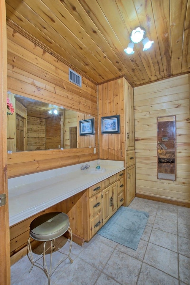 bathroom featuring sink, wooden walls, and wood ceiling