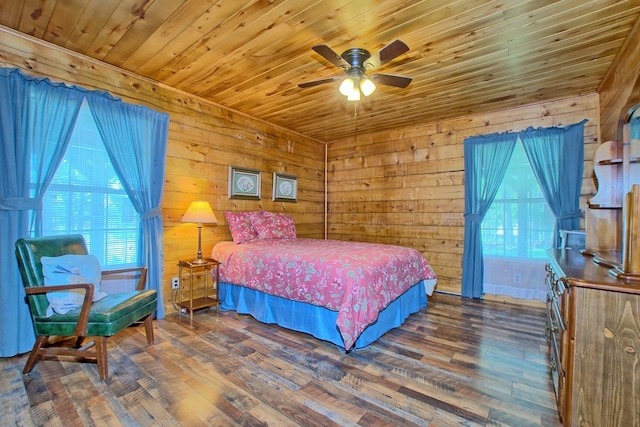 bedroom with ceiling fan, wood walls, dark hardwood / wood-style flooring, and multiple windows