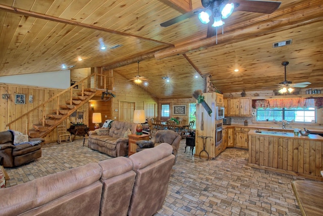 living room featuring high vaulted ceiling, wooden ceiling, and wood walls