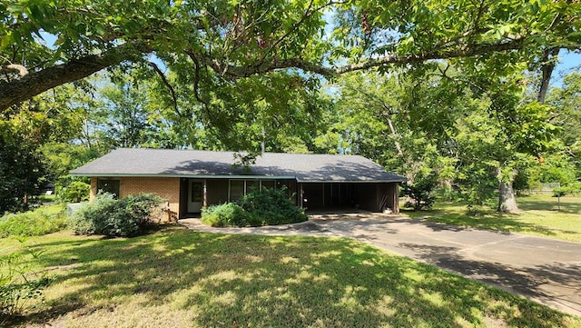 ranch-style house featuring a carport and a front lawn