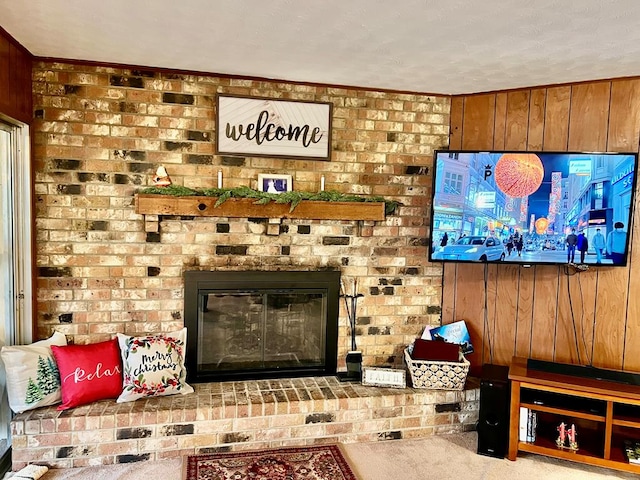 carpeted living room featuring a textured ceiling, a fireplace, and wooden walls