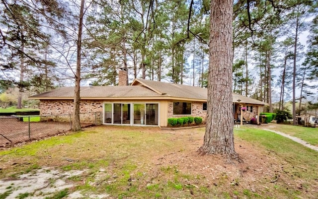 rear view of property with a lawn