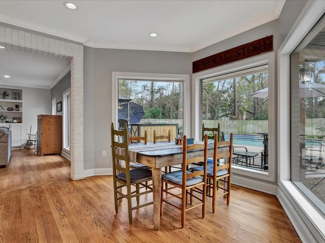 dining room with light hardwood / wood-style flooring and crown molding