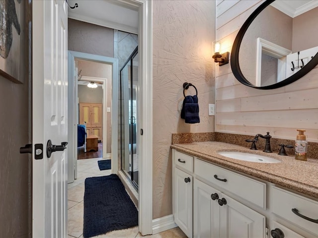 bathroom with tile patterned floors, vanity, a shower with shower door, and crown molding