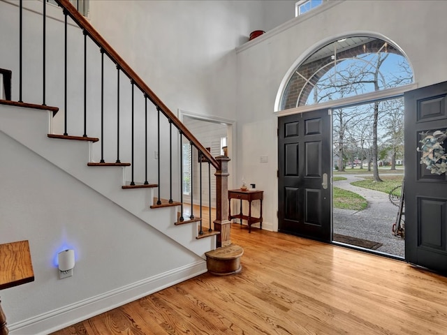 entryway with light hardwood / wood-style flooring and a high ceiling