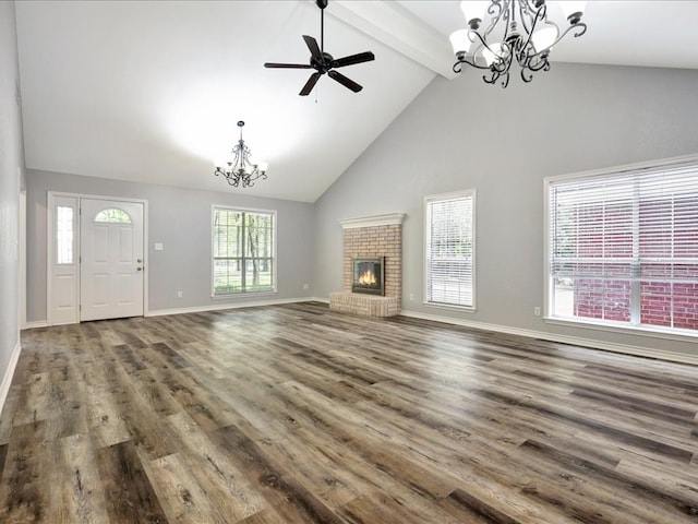 unfurnished living room with high vaulted ceiling, beamed ceiling, wood-type flooring, a fireplace, and ceiling fan with notable chandelier