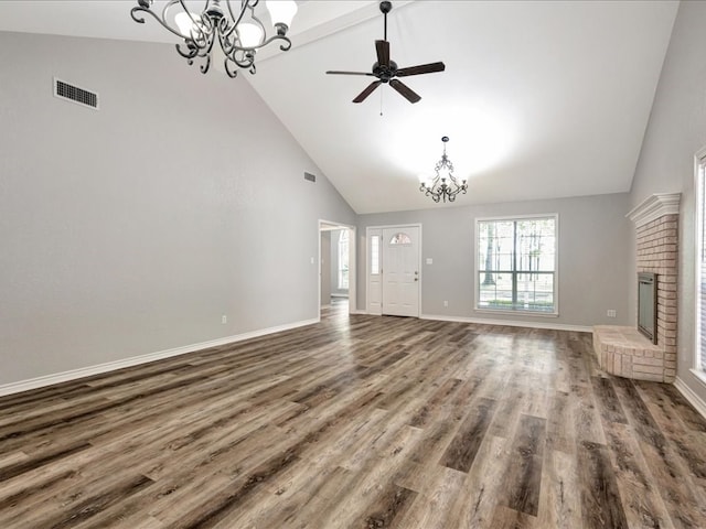 unfurnished living room with visible vents, high vaulted ceiling, a brick fireplace, and wood finished floors