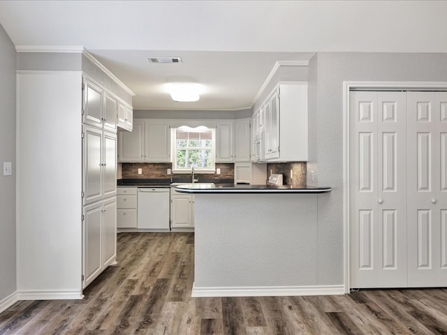 kitchen featuring white appliances, dark wood-style floors, dark countertops, and tasteful backsplash