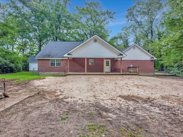 back of property featuring fence, brick siding, and a wooden deck